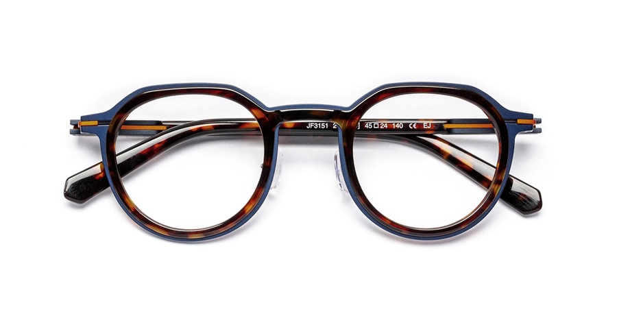 Lunettes J.F. Rey série SLEDGE modèle JF3151 en écaille et bleu marine, repliées à plat. La monture géométrique arrondie en acétate associe un motif écaille brun sur la façade à un bord extérieur et des branches bleu profond, avec des accents dorés visibles sur la charnière Flex.