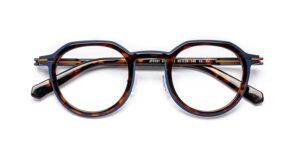 J.F. Rey SLEDGE series eyeglasses model JF3151 in tortoiseshell and navy blue, folded flat. The rounded geometric acetate frames pair a brown tortoise pattern on the front with a deep blue outer edge and temples, with gold accent details visible on the Flex hinge.