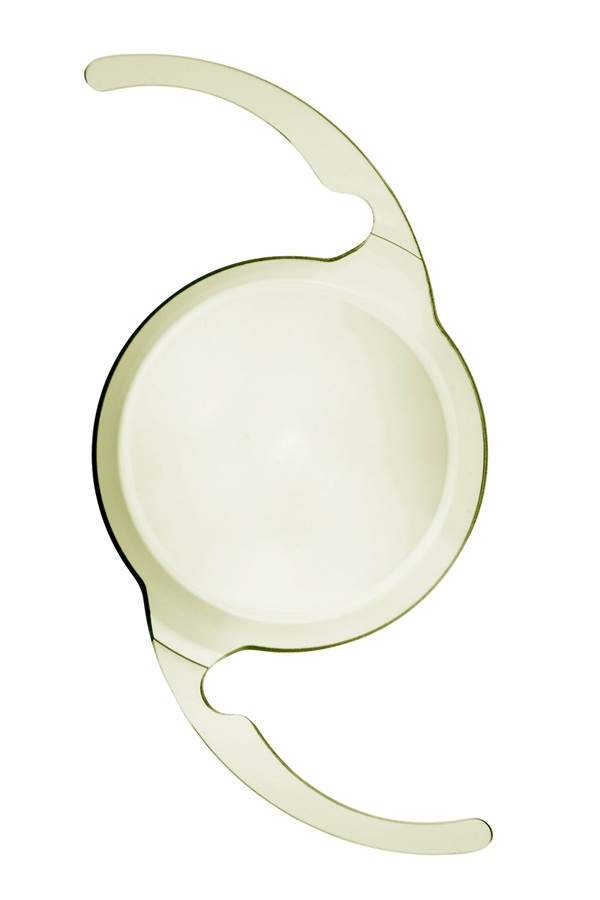 Close-up of the TECNIS PureSee intraocular lens, showing its circular optic and curved haptic arms used to hold the lens in place after cataract surgery