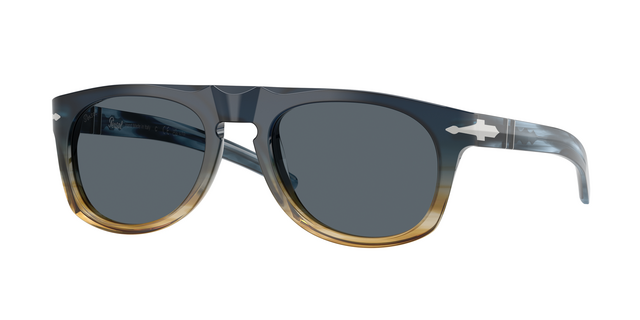 Persol x Cassina limited-edition sunglasses in a gradient blue acetate frame fading to honey, with dark grey lenses and silver arrow detail on the temples — one of 500 numbered collectible pieces from the collaboration.