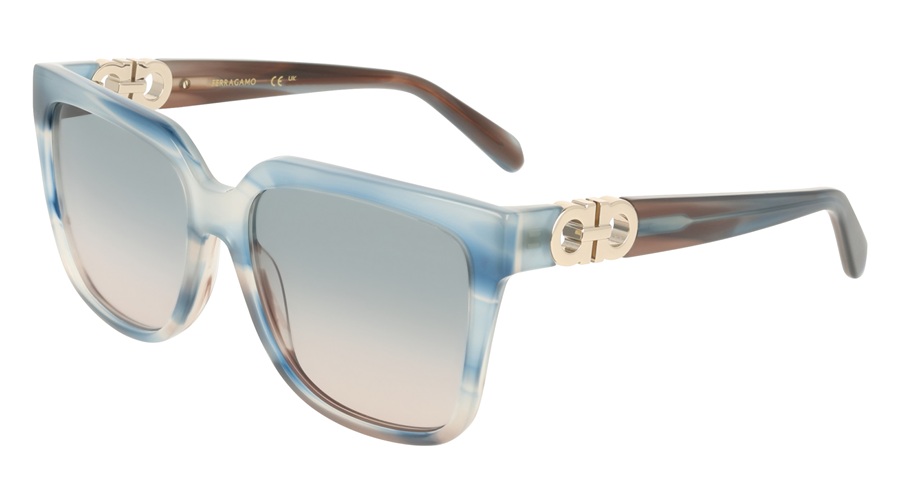 Ferragamo SF2109S sunglasses in Sand Striped Blue/Gradient Avio Rose, shown in three-quarter profile view. The oversized rectangular acetate frame features a blue and cream marble-effect pattern with brown tortoiseshell temples. A gold-tone Double Gancini jewel detail adorns the hinge. Lenses are gradient blue-grey to rose.