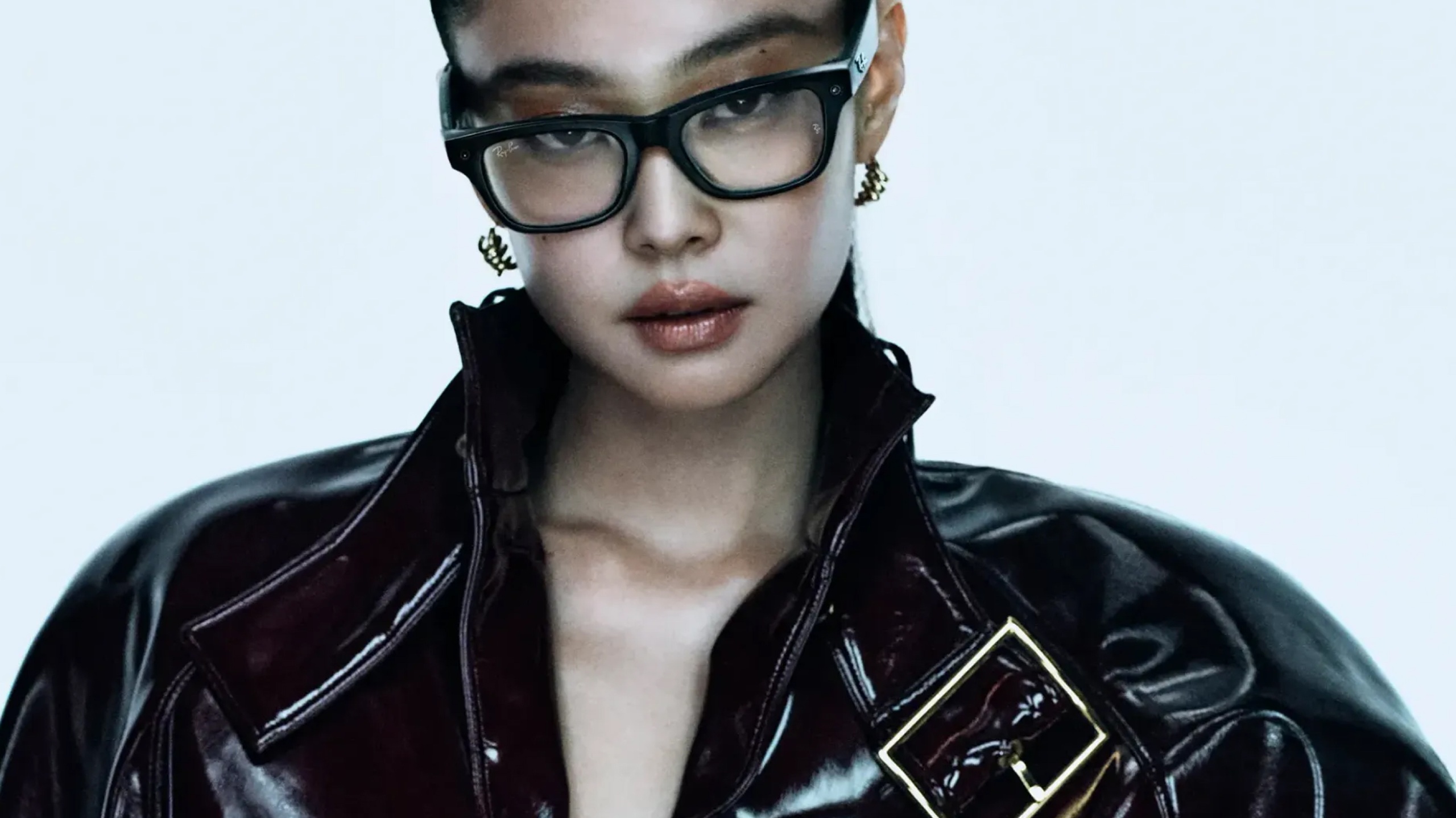 Ray-Ban global ambassador Jennie wearing black rectangular Ray-Ban frames and a dark patent leather jacket in the brand's campaign