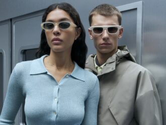 Deux modèles présentant la collection SS26 : une femme portant des lunettes de soleil ovales claires et un homme avec une monture rectangulaire blanche épaisse.