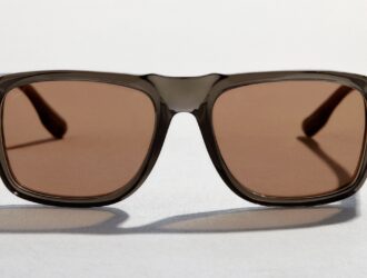 Vue de face de lunettes de soleil Persol présentant une monture translucide gris fumé et des verres brun chaud.