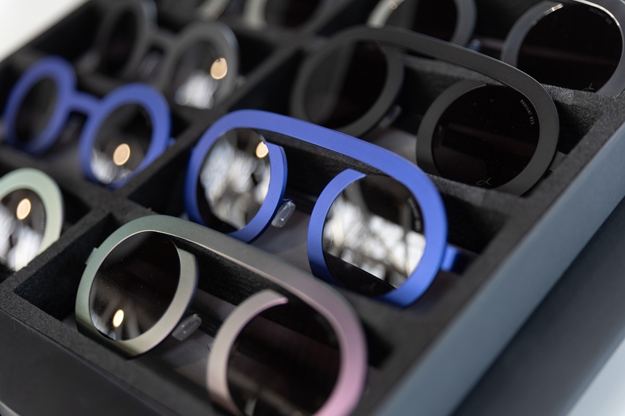 Un présentoir de montures de lunettes indépendantes dans diverses couleurs, dont le bleu, le noir, le vert et le rose, présentées lors de DaTE 2025
