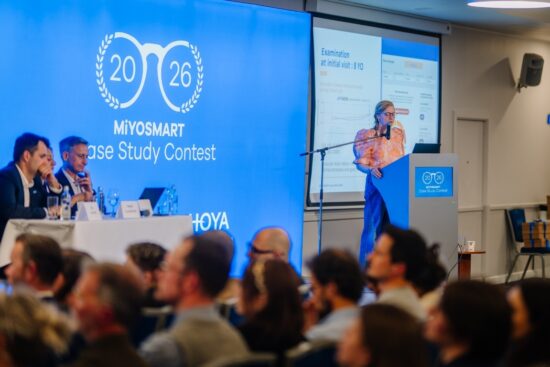 Marion Wolff presenting her clinical case study from a podium to a large audience at the MiYOSMART Case Study Contest.