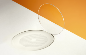 Une lentille ophtalmique HOYA MiYOSMART iQ transparente projetant une ombre qui révèle la structure en nid d'abeille de la technologie D.I.M.S.
