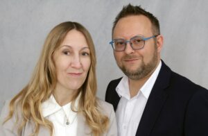 Portrait of two Chamborelle family members, a woman and a man wearing blue glasses