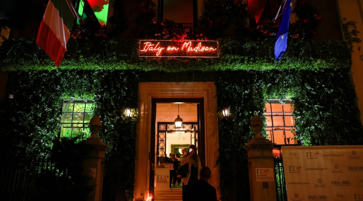 Entrance of the Italy on Madison event venue at night, with a red neon sign and ivy-covered facade
