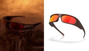 A split-screen product image of the Oakley Highland Jaylen Brown Signature Series. The left side shows the eyewear resting on a bed of dark, swirling smoke. The right side features a clean studio shot of the cocoa brown frame and Prizm Ruby lenses, highlighting the "FCHWPO" etching on the lens and the metallic Oakley logo on the temple.