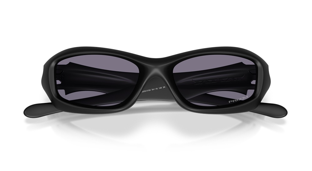 Vue de face de la Oakley MUZM FatCat en « Matte Black », mettant en valeur sa structure organique iconique et ses verres sombres Prizm Grey.