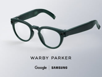 Lunettes intelligentes vert foncé à monture ronde de Warby Parker présentées dans un rendu studio, avec caméras intégrées et fonctionnalités alimentées par l’IA créées avec Google et Samsung.