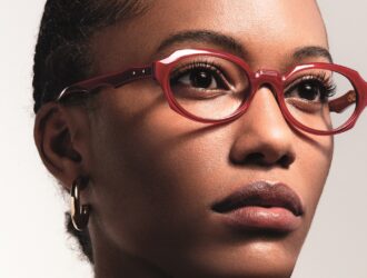 Portrait rapproché d'une femme portant des lunettes de vue en acétate rouge brillant de la collection ONDA.