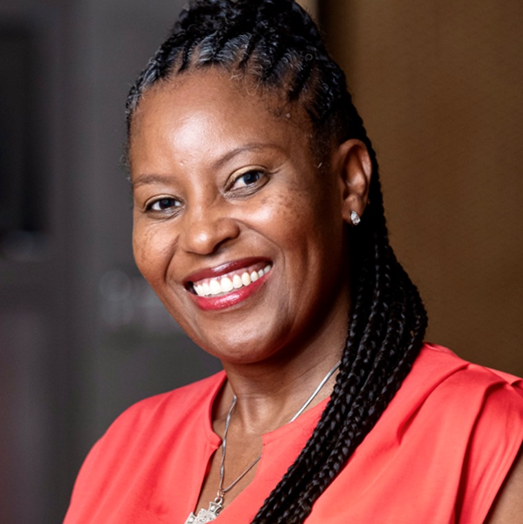 Headshot of Ms. Ntombikayise Zitha smiling, with braided hair in a high ponytail, wearing a red top and a silver necklace.