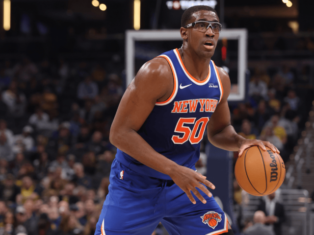 Le joueur de basket-ball des New York Knicks, Trey Jemison III (numéro 50), portant des lunettes de protection transparentes tout en dribblant avec le ballon sur le terrain pendant un match.