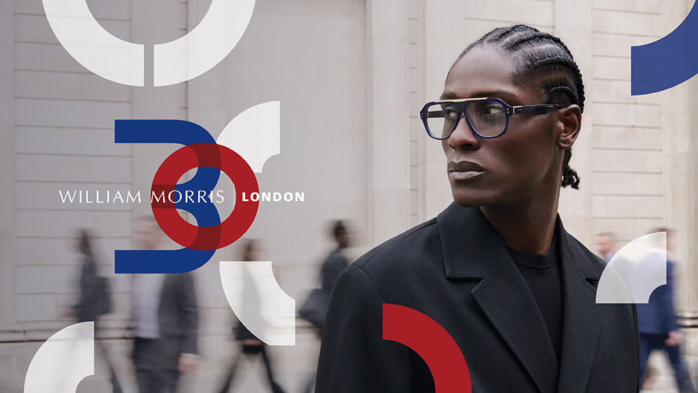 William Morris London 30th anniversary campaign banner featuring a model wearing dark blue Royal aviator glasses on a London city street background with the 30 years monogram logo.