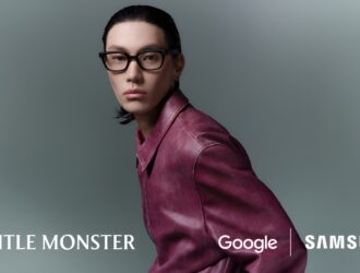 Lifestyle portrait of a male model wearing the black Samsung Intelligent Eyewear (Gentle Monster design) and a maroon leather jacket. The image emphasizes the thin design and stylish appearance. logos for Gentle Monster, Google, and Samsung are displayed.