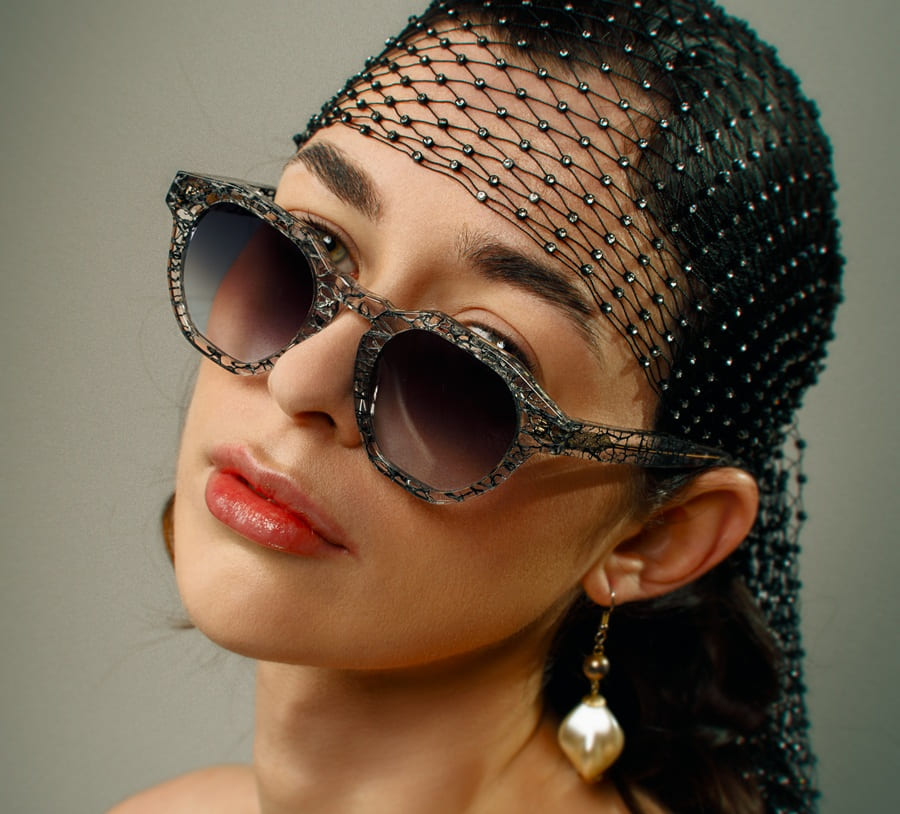 Mannequin portant des lunettes de soleil éco-responsables Ferilli Eyewear avec motifs naturels de fibres de cactus et une coiffe en résille noire