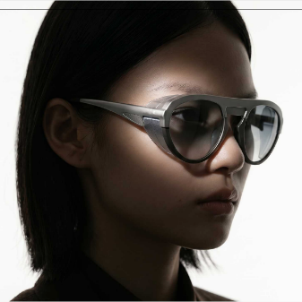 Femme portant des lunettes de soleil aviateur grises au double pont sculpté. 