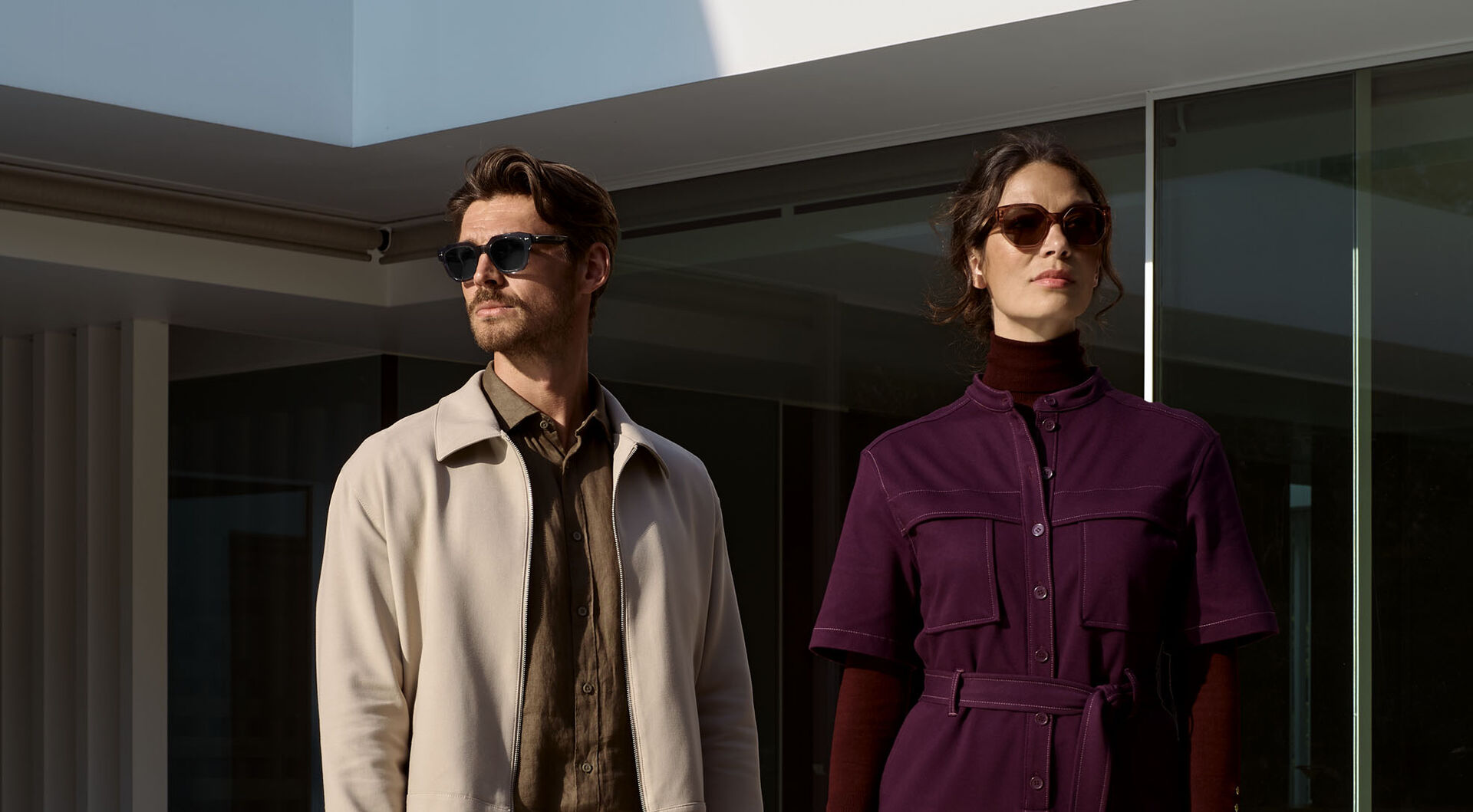 Man and woman wearing HOYA Sensity 3 photochromic eyewear in Silver Grey and Bronze Brown, showcasing light-adaptive lens technology outdoors