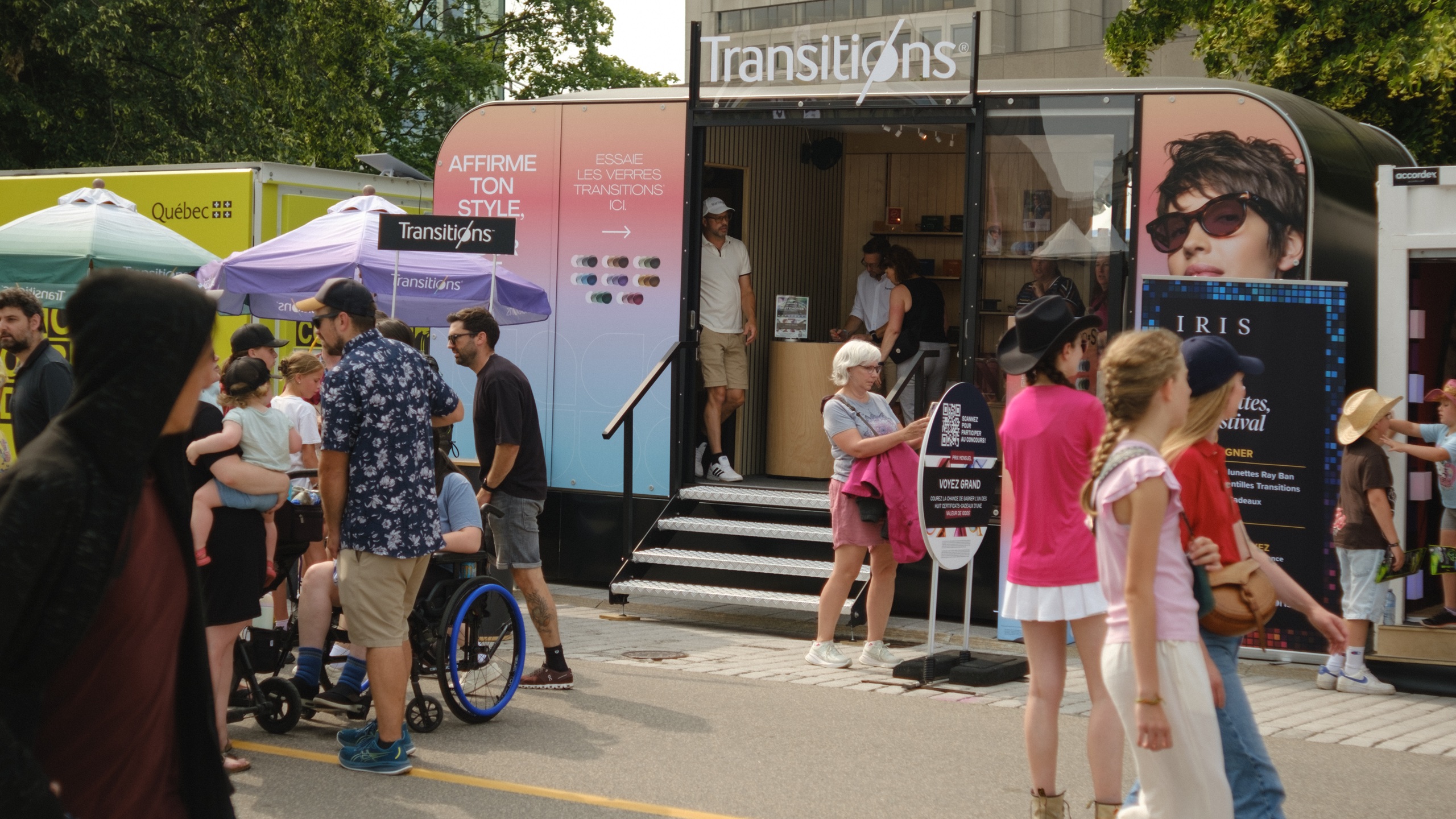 Kiosque éphémère Transitions® sur la Grande Allée durant le Festival d'été de Québec, où les visiteurs découvrent les couleurs et styles de verres.