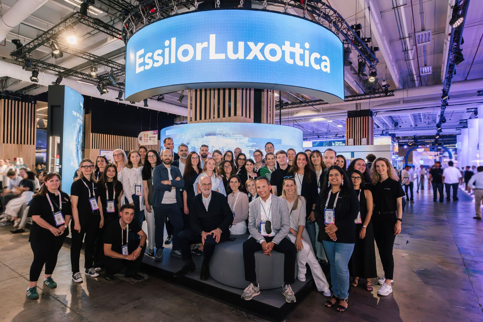 The EssilorLuxottica team posing for a group photo under a large digital banner at VivaTech 2026.