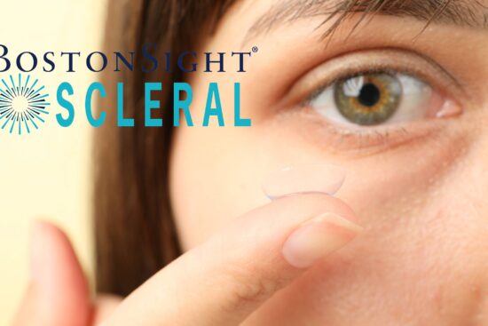Close-up of a person holding a clear BostonSight SCLERAL lens near their eye