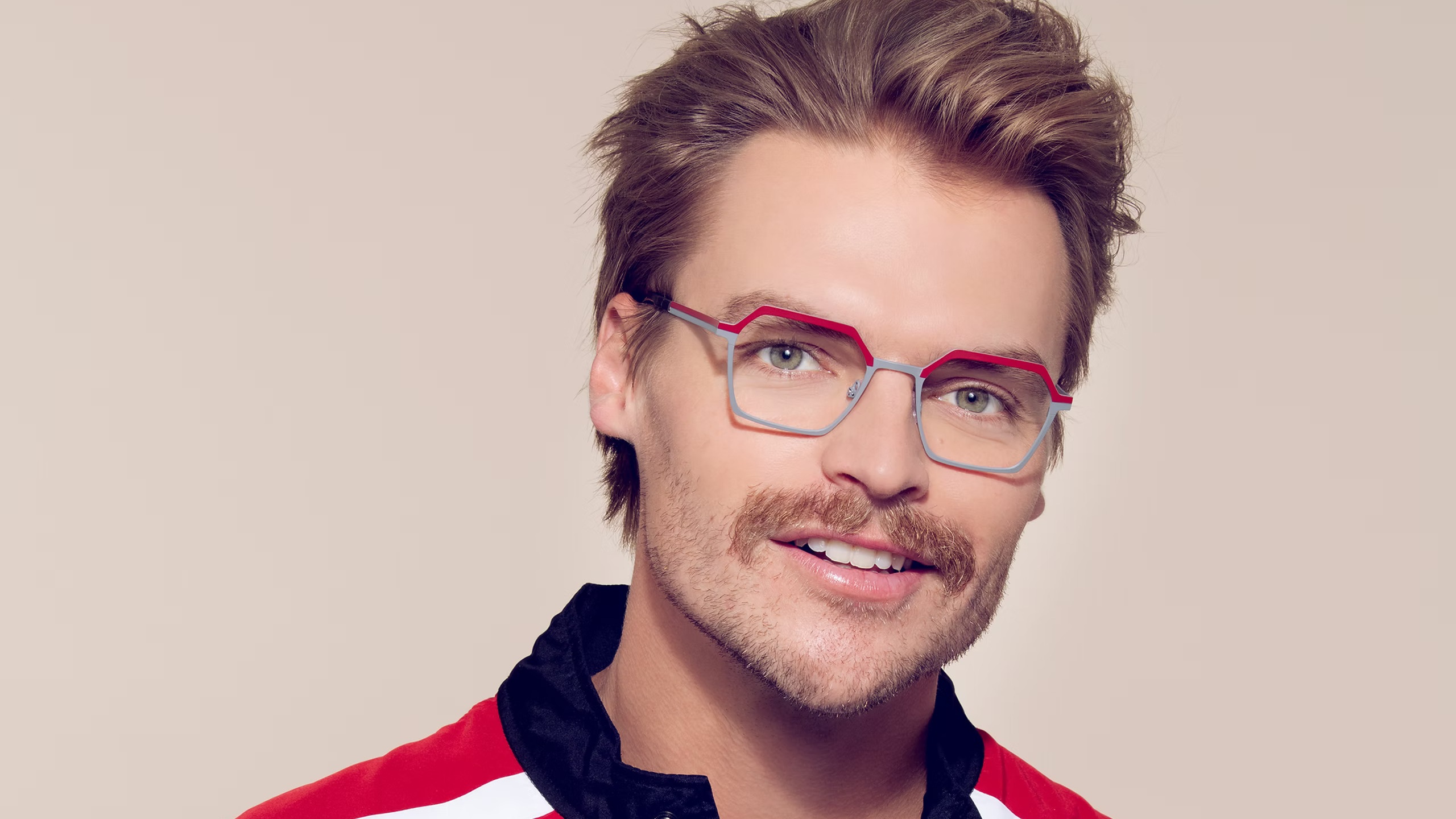 Model wearing OGI geometric metal glasses featuring silver rims and red-orange brow accents.