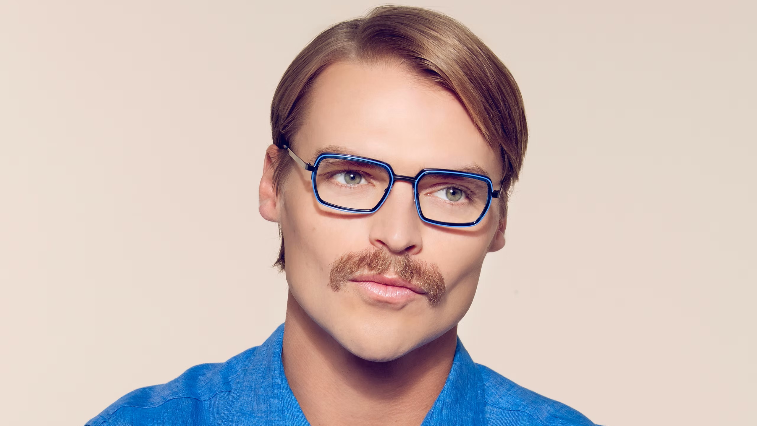 Man wearing blue OGI rectangular eyeglasses with bright blue eye rim accents