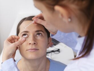 Eye doctor administering eye drops to a patient during a dry eye exam