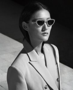 Portrait en noir et blanc d'un mannequin portant les lunettes de soleil cat-eye Bacall d'ic! berlin dans la campagne Manifesto.