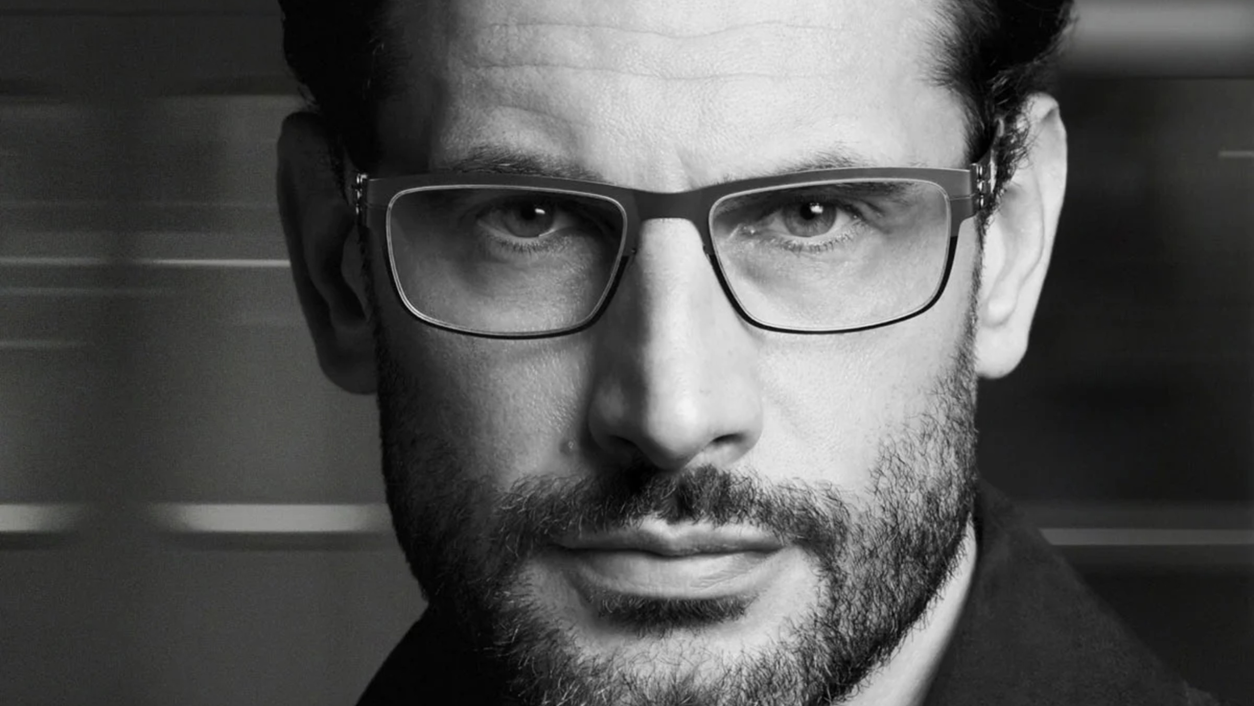 Close-up campaign portrait of a man wearing ic! berlin Thilo rectangular optical glasses.