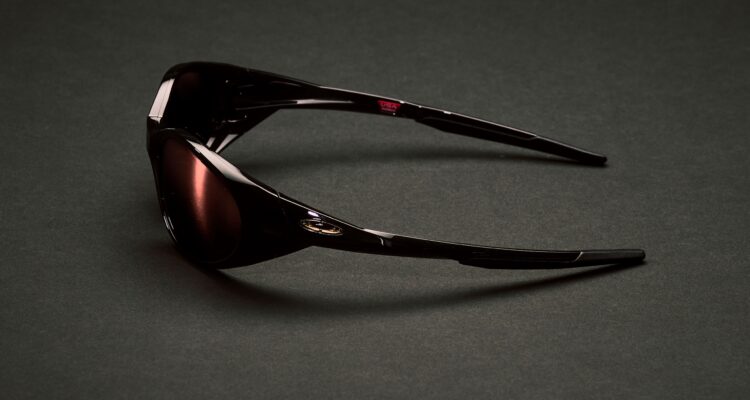 Vue de profil des lunettes de soleil Cactus Jack x Oakley Eye Jacket Redux dans un coloris sombre exclusif sur fond noir