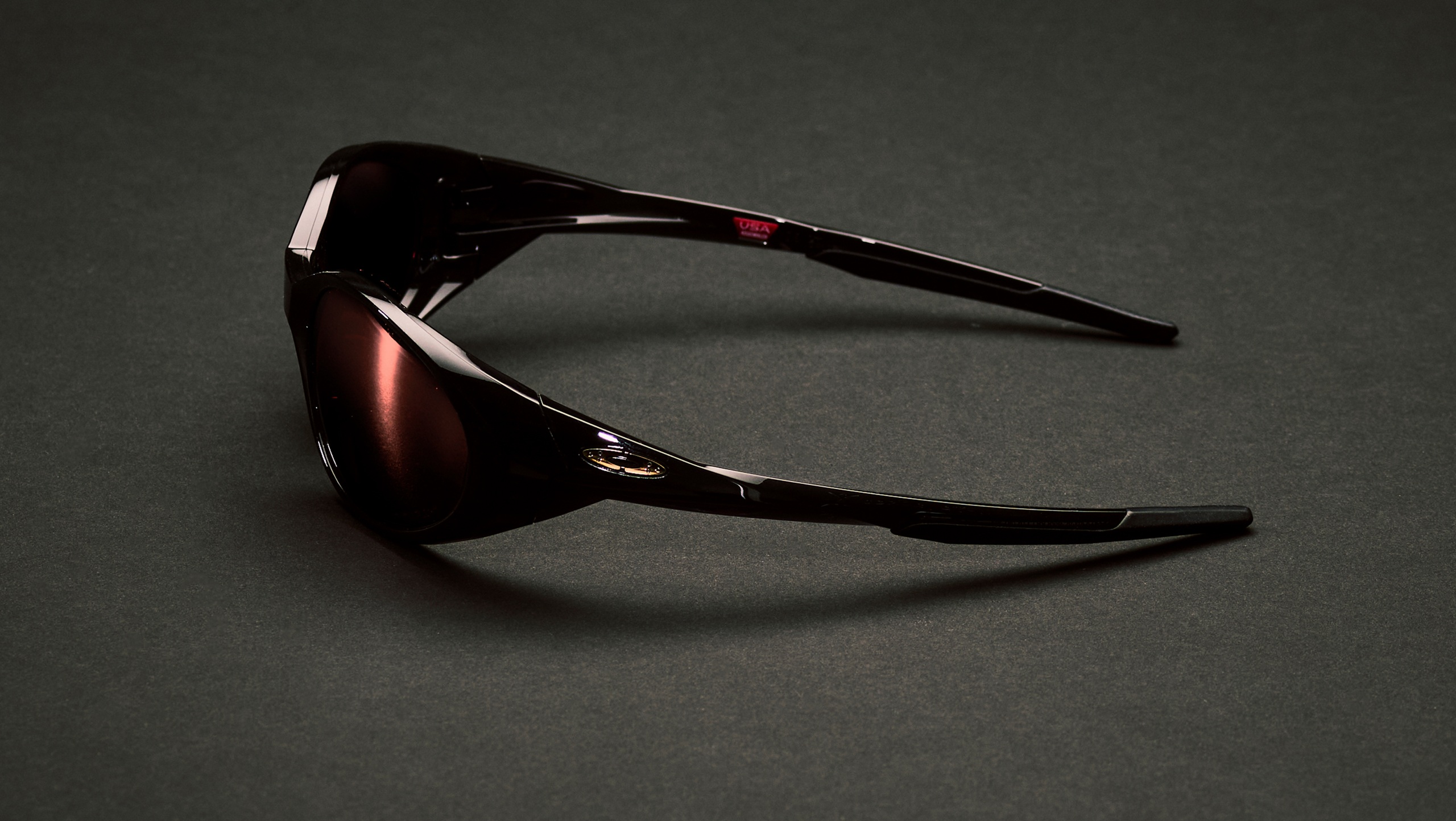 Vue de profil des lunettes de soleil Cactus Jack x Oakley Eye Jacket Redux dans un coloris sombre exclusif sur fond noir