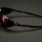 Side view of Cactus Jack x Oakley Eye Jacket Redux sunglasses in exclusive dark colorway on dark surface