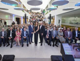 Grand rassemblement de personnes dans le hall moderne du Vision Centre de CooperVision lors de son inauguration, avec l'équipe et les invités installés dans le grand atrium.