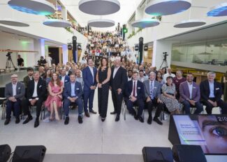 Group photo at the opening event for The Vision Centre, showcasing the large audience on tiered seating in the modern atrium space.