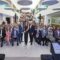 Group photo at the opening event for The Vision Centre, showcasing the large audience on tiered seating in the modern atrium space.