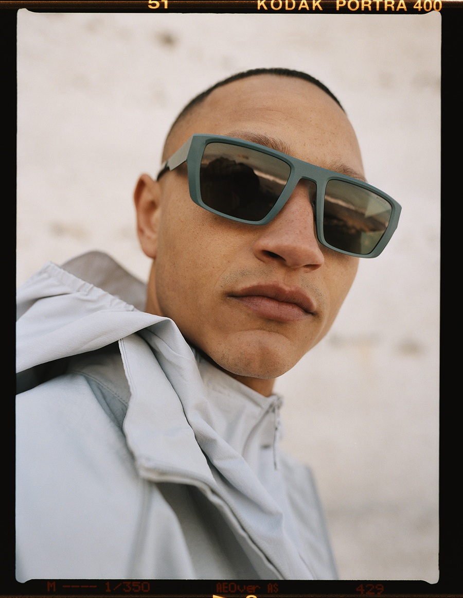 Gros plan d'un homme portant les lunettes de soleil de la collection Ørgreen Sheet Titanium SUN, avec une monture bleu sarcelle mate et des verres fumés.