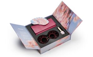 Product shot of the opened J.F. REY x ROBERTET SAKURA limited edition coffret, including the sunglasses, red leather case, and bespoke fragrance bottle.