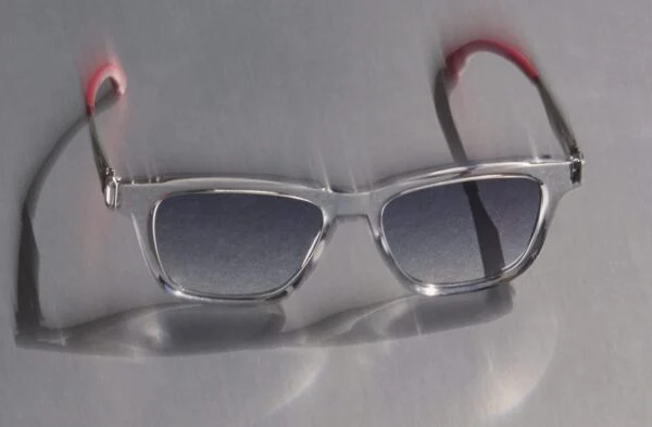 The ic! berlin "Gabriel" sunglasses from the Racing Edition, featuring a clear grey acetate frame with red temple tips.