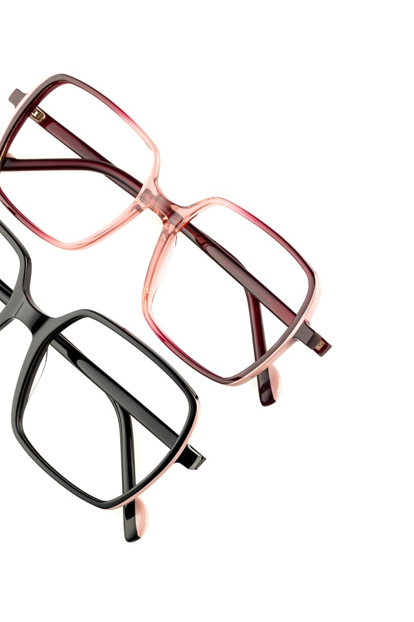 Close-up view of two oversized square eyewear frames from the TREE Spectacles MARKS collection, showing one in translucent rose gradient and one in solid black.