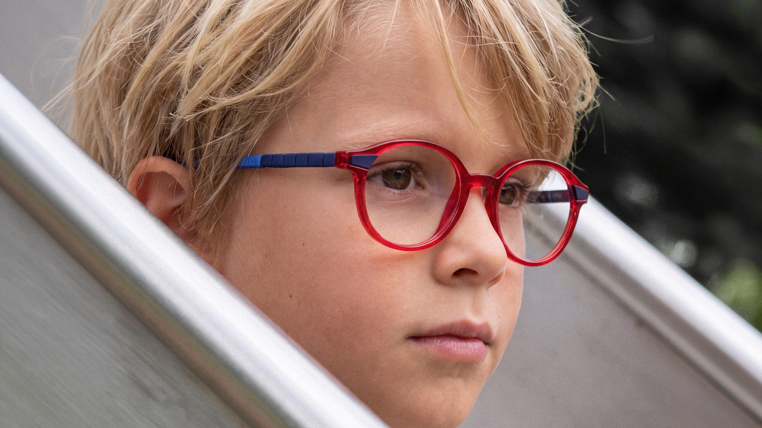 Jeune garçon portant les lunettes LOOKKINO TRI-X 3946 rouges et bleues conçues pour les enfants actifs de 5 à 9 ans