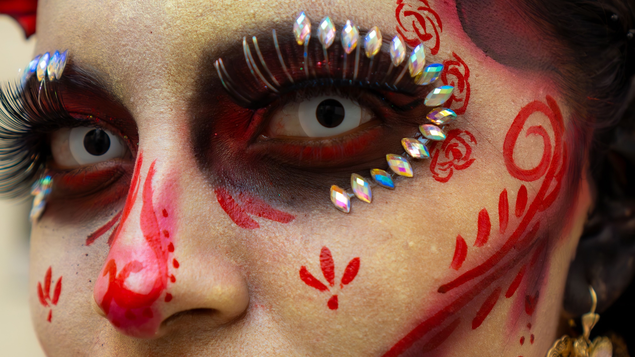 Gros plan sur un maquillage de Halloween élaboré avec des lentilles de contact cosmétiques blanches.