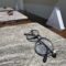 Alt text: Light MONTESTELLA bio-based carbon fiber optical frames displayed on a natural stone exhibit surface.