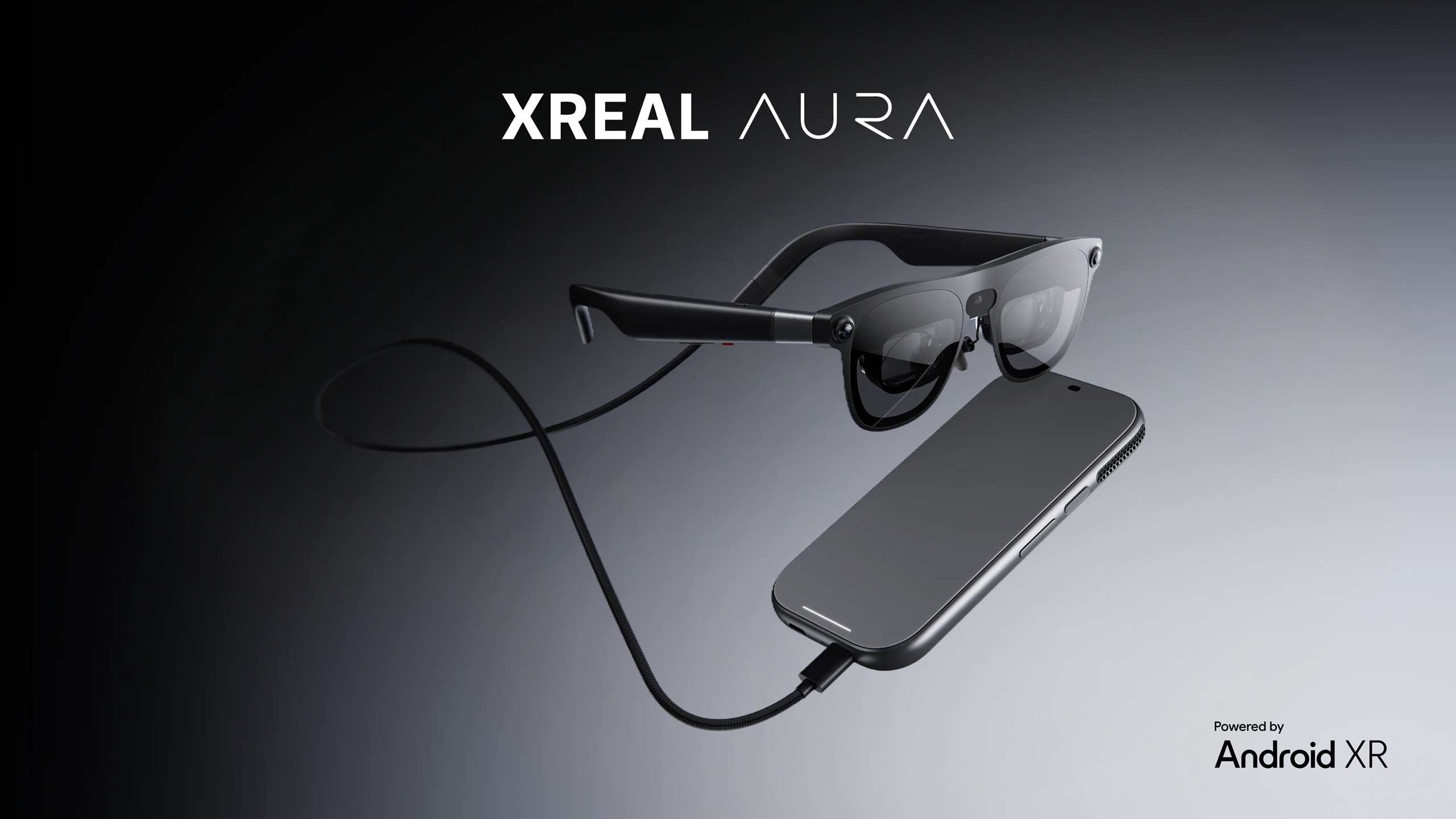 XREAL AURA spatial computing glasses connected by cable to a trackpad compute puck powered by Android XR.
