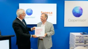 Seneca Polytechnic President David Agnew holding the CooperVision Contact Lens Centre of Excellence plaque with a CooperVision representative.