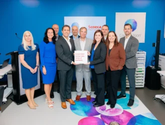 Les dirigeants du Seneca Polytechnic et les représentants de CooperVision pose avec la plaque inaugurale du Centre d'excellence en verres de contact.